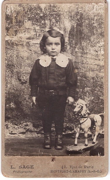 Enfant posant à côte de son cheval-jouet.