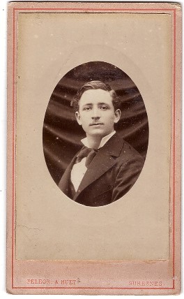 Jeune homme posant devant un drap noir plissé