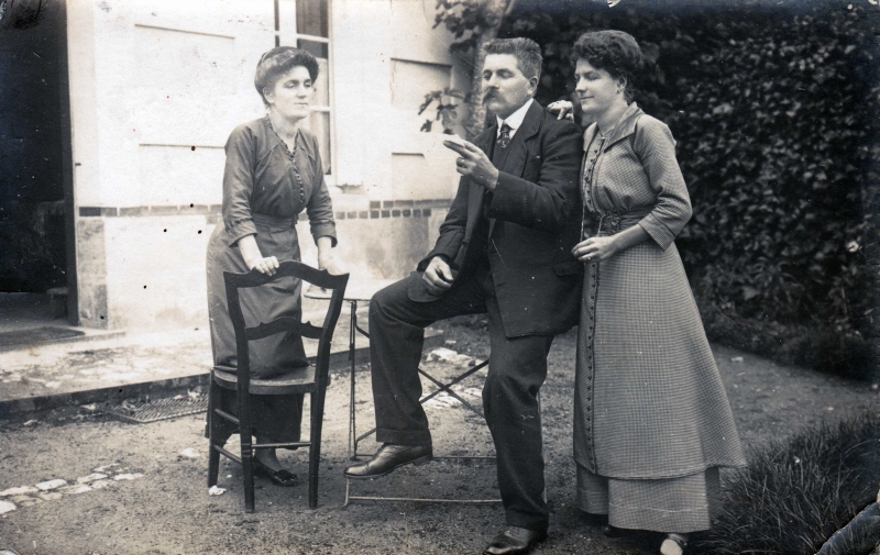 Un homme et deux femmes dans le jardin de leur maison
