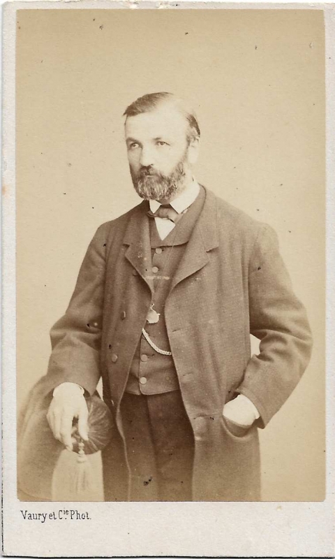 Homme debout, une main dans la poche de son manteau