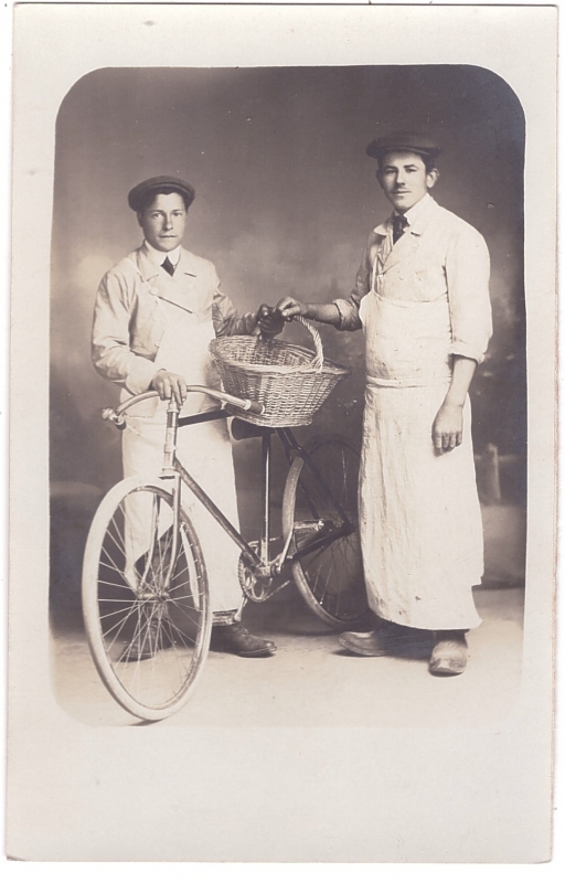 Garçons bouchers posant à côté d'une bicyclette
