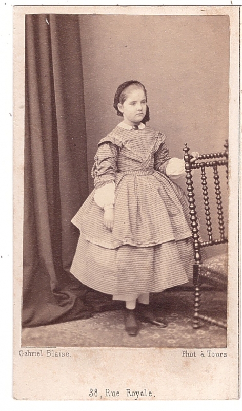 Jeune demoiselle  debout près d'une chaise