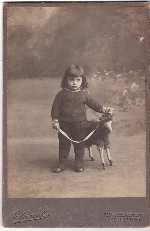 Enfant posant à côté d'un mouton à roulettes