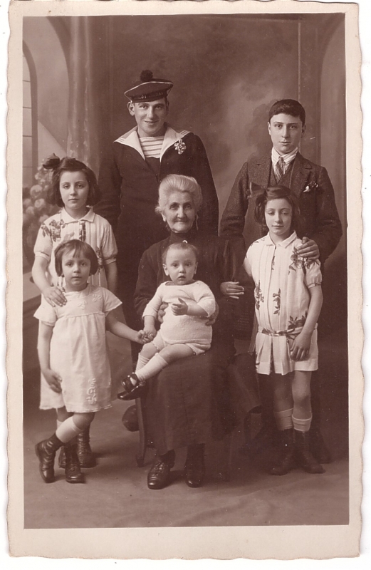 Femme âgée entourée de ses petits-enfants dont un marin