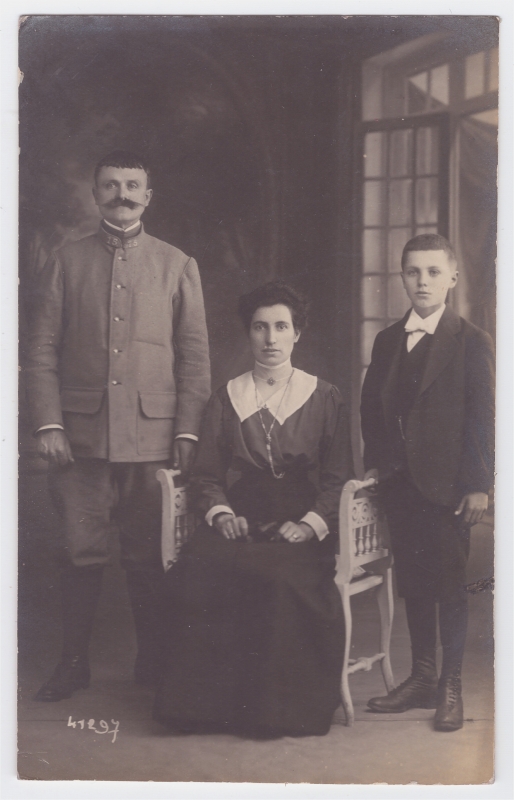 Parents -le père en uniforme- posant avec leur fils