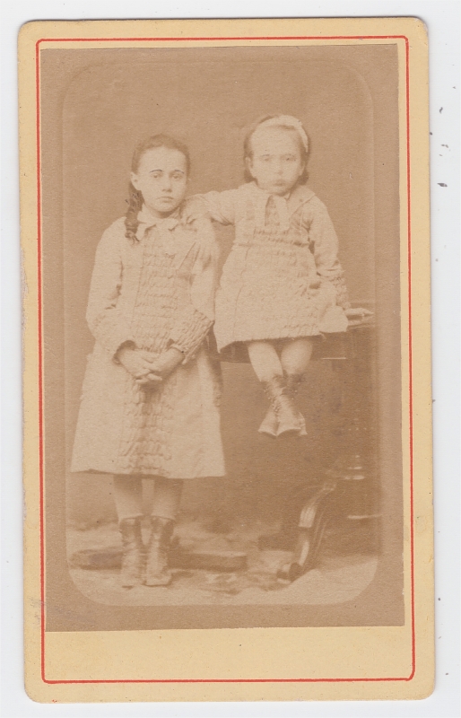 Deux soeurs, la plus jeune assise sur une table