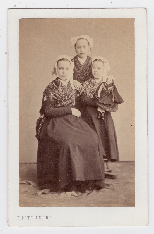 Trois soeurs (?) en habit traditionnel ; la plus jeune tenant une poupée