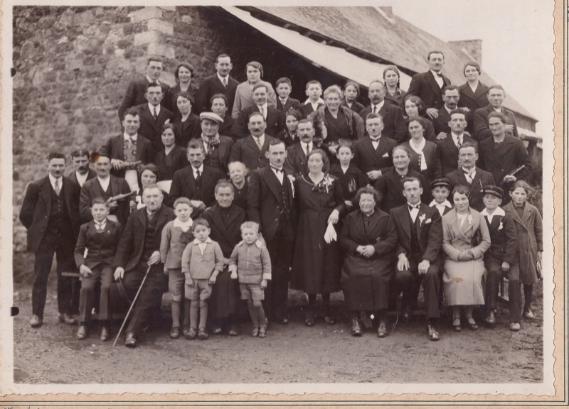 Groupe de noces posant dans une cour de ferme