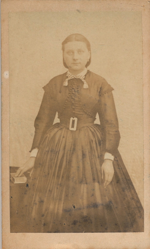 Jeune femme ceinturée dans sa robe à plis