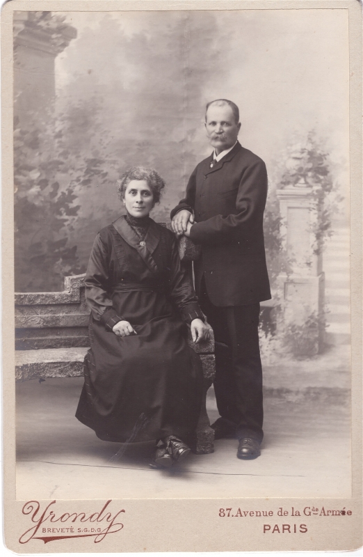 Couple  posant en atelier ; elle, assise sur un banc factice