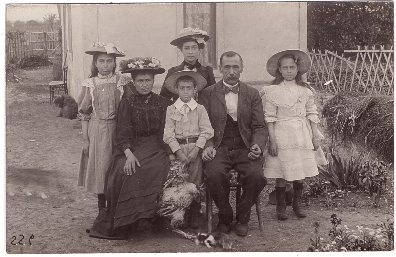 Couple avec quatre enfants posant dans leur jardin