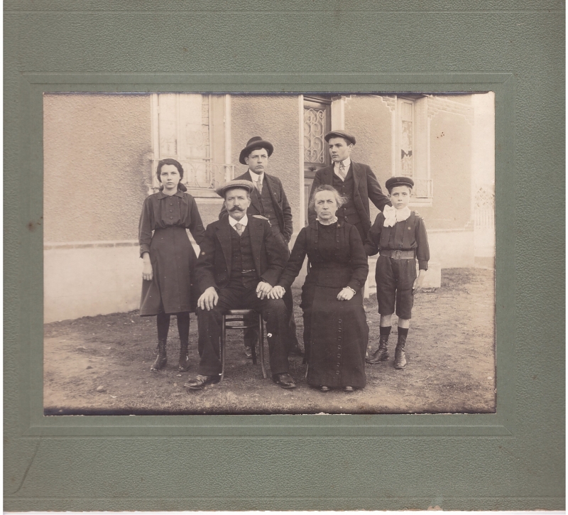 Un couple et leurs quatre enfants (?) posant devant leur maison