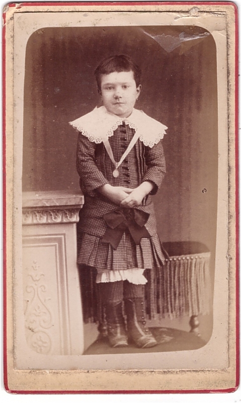 Enfant, les épaules couvertes d'un large col de dentelle