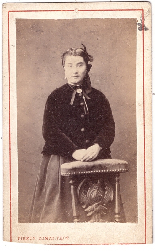 Femme posant debout derrière une chaise