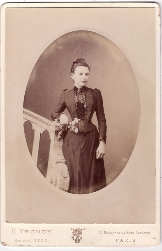 Jeune femme à la taille de guêpe tenant des fleurs