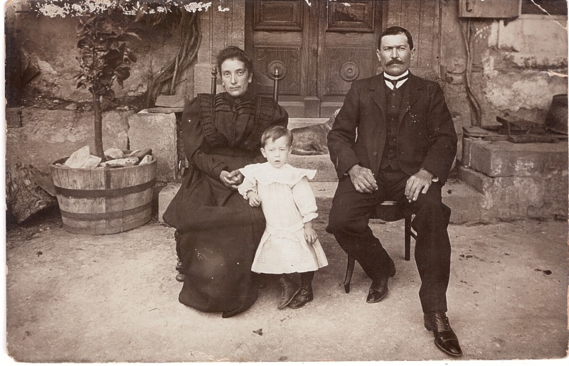 Couple et leur jeune enfant posant devant chez eux