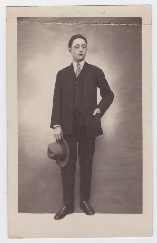 Jeune homme tenant son chapeau