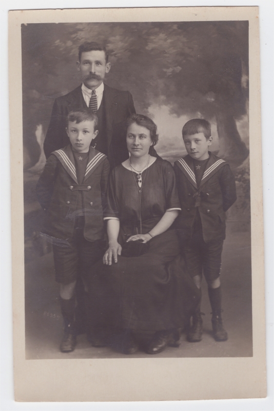 Parents posant avec leurs deux garçons en tenue de marin