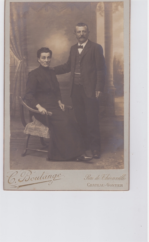 Couple d'âge mûr : lui debout ; elle assise