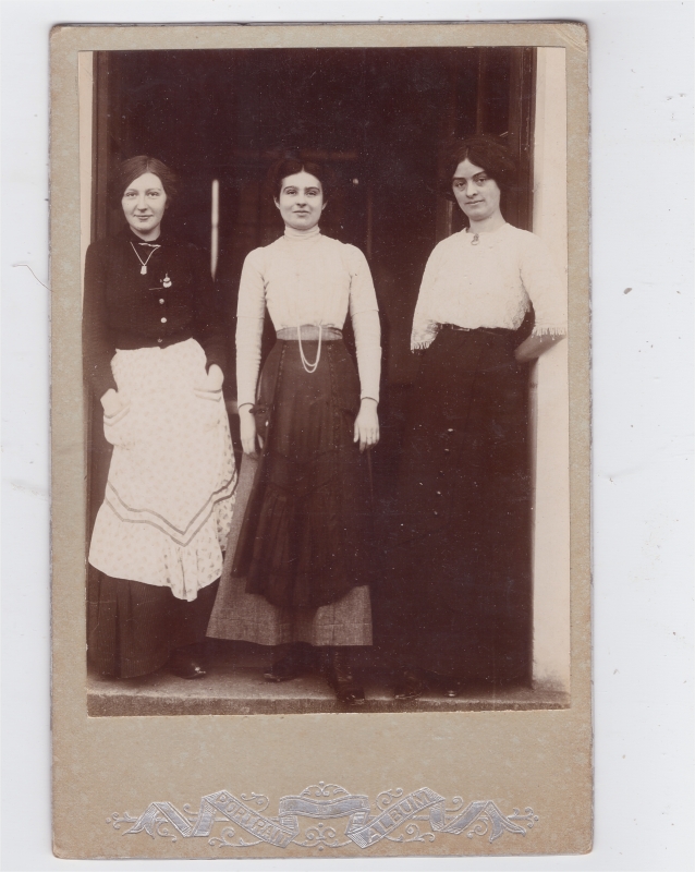 Trois jeunes femmes dans l'encadrement d'une porte