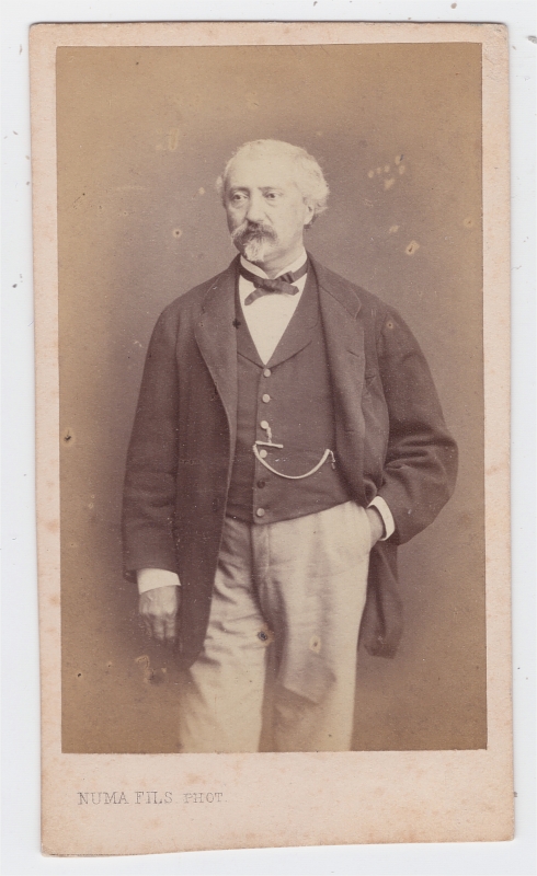 Homme aux cheveux blancs, une main dans  la poche de son pantalon