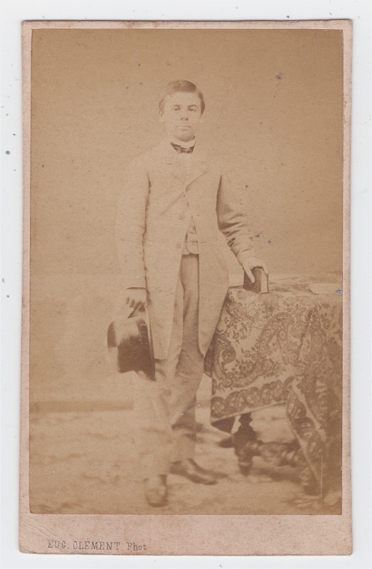 Homme jeune tenant à la main son chapeau