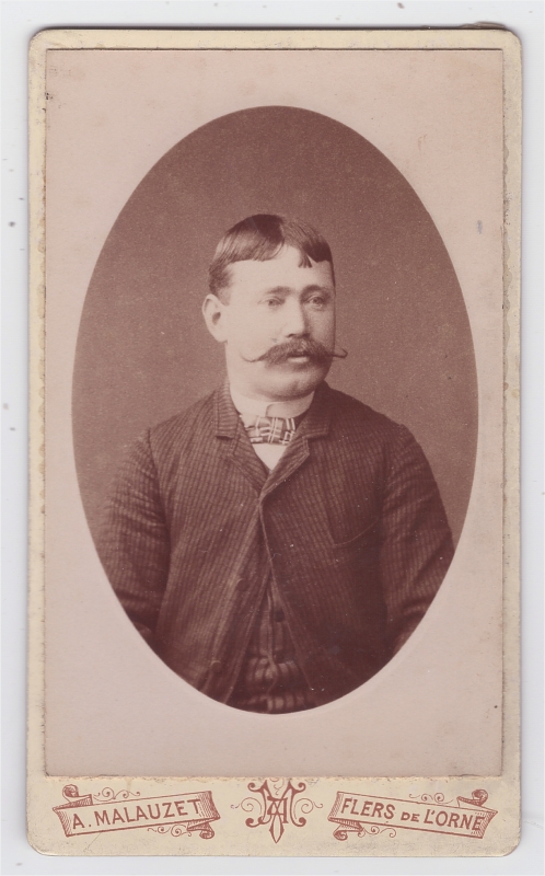 Homme, cheveux courts et longue moustache effilée